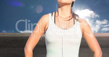 Fitness woman Torso listening music against countryside background