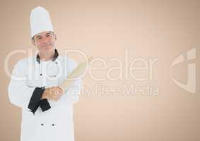 Chef with rolling pin against cream background