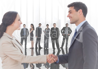 Composite image of Handshake in front of business people at window