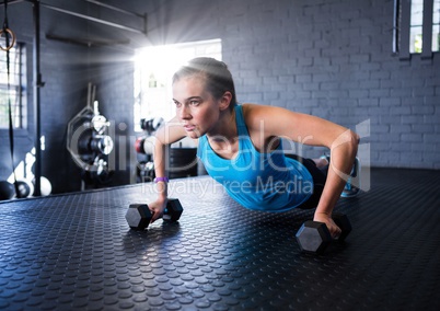 Fitness woman making fitness exercises in a gym with flare