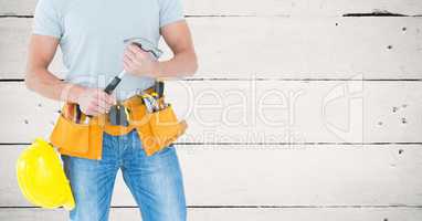 Composite image of Carpenter with hammer against white wood panel