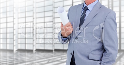 Architect Torso holding plans in a corridor against windows