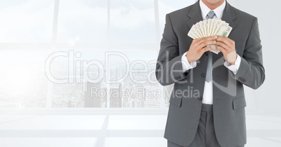 Businessman Torso holding bills against windows