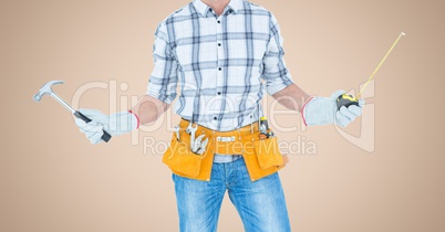 Carpenter with hammer and measuring tape against cream background