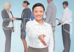Composite image of  Handshake in front of business people with blue background