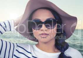 Composite image of Woman in summer hat against sea with flare