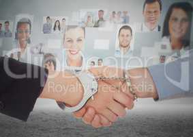 Composite image of Handshake with handcuffs in front of sky with business people