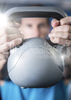 Fitness man holding kettle bell with flare in front of him