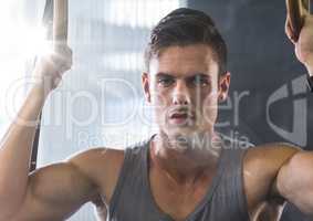 Composite image of Man doing pull ups with flare
