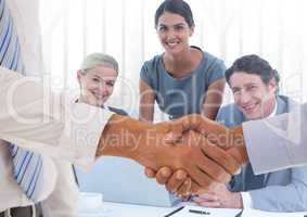 Handshake in front of business people in office