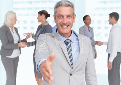 Composite image of Handshake in front of business people in office