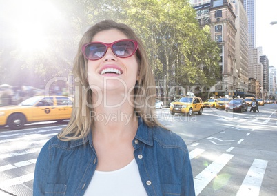 Woman with sunglasses on street with flare against city background