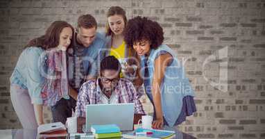 Composite image of People around laptop against brick wall