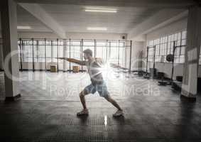Man stretching in gym with flare
