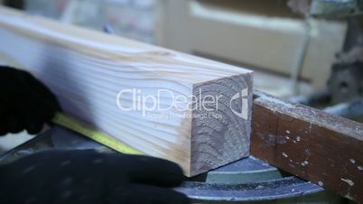Circular saw cutting wooden plank in workshop.