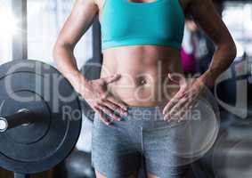 Composite image of Woman's torso in gym with flare