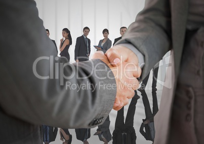 Composite image of Handshake in front of business people at window