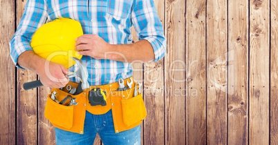 Composite image of Carpenter with hammer against wood panel