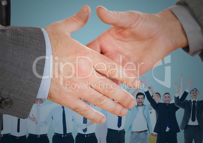 Handshake in front of business people with blue background