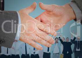 Handshake in front of business people with blue background