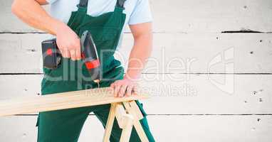 Carpenter drilling against white wood panel