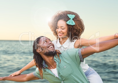 Composite image of Couple against sea with flare