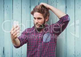 Man taking selfie against blue wood panel background