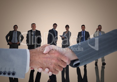 Composite image of Handshake in front of business people with cream background