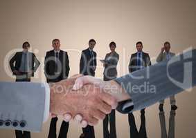 Composite image of Handshake in front of business people with cream background