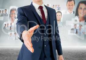 Composite image of Handshake in front of sky with business people