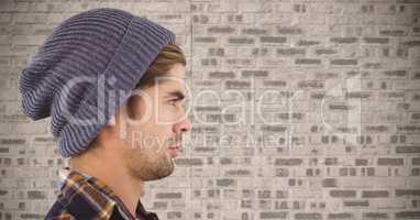 Composite image of Man with beanie against brick wall