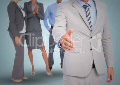 Composite image of Handshake in front of business people against blue backgrund