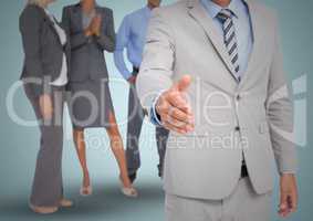 Composite image of Handshake in front of business people against blue backgrund