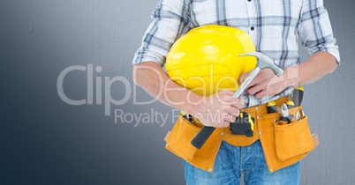 Carpenter with hammer against grey background