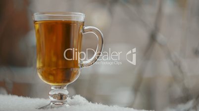 Steaming Cup Of Hot Tea In Snowy Winter