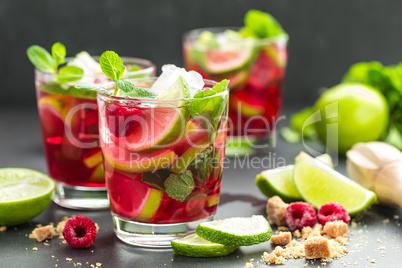 Raspberry mojito cocktail with lime, mint and ice, cold refreshing drink