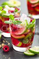 Raspberry mojito cocktail with lime, mint and ice, cold refreshing drink