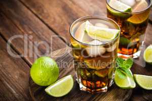 Cuba Libre cocktail with cola, lime and ice in glass, cold longdrink