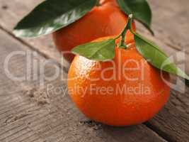 Two fresh orange fruits on wood
