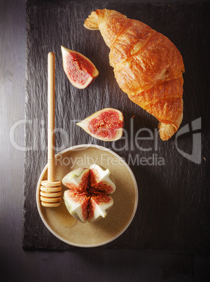 Croissant and figs on a stone plate