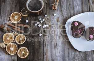cup of hot black coffee and cakes on a white plate