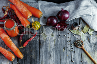 Ripe fresh orange carrots with fresh juice in a small jar