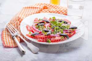 Grapefruit salad with olives, red onion, basil