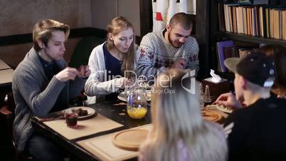 Hipster teenagers enjoying snack together in cafe