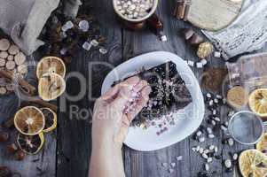 Female hand sprinkles sugar hearts piece of Sachertorte