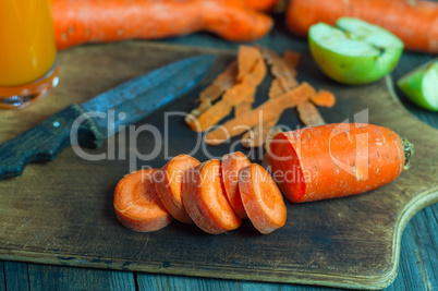 Cut into round slices of carrot on the kitchen brown wooden boar