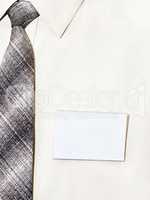 blank badge pinned to his shirt