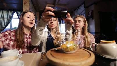 Female friends taking food picture with smartphone