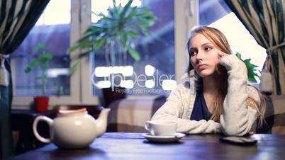 Impatient girl waiting for her boyfriend in cafe