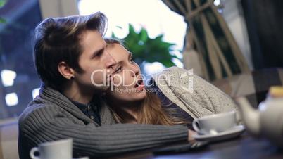 Loving young couple hugging while resting in cafe